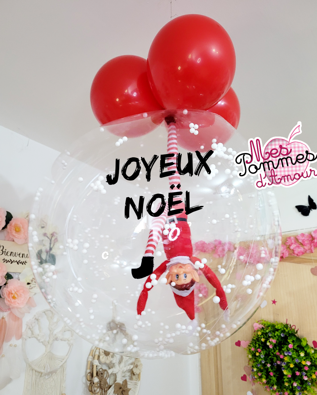 Ballon bulle personnalisé pour Noël avec lutin farceur à l'intérieur accroché par le pied inscription joyeux Noël dessus